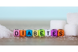 Mit farbigen Perlen gelegt das Wort Diabetes zwischen Zuckerwürfeln, um auf die weitverbreitete Zuckerkrankheit aufmerksam zu machen.