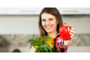 Frau hält Paprika als ein Lebensmittel mit Antioxidantien in die Kamera