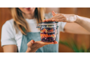 Frau mit einem Glas mit fermentiertem Gemüse