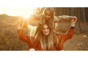 Frau und Kind tanken Vitamin D im Herbst in der Sonne