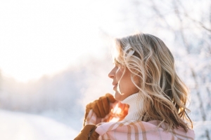 Frau im Winter tankt Vitamin D im Sonnenschein