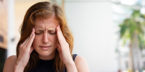 Frau leidet unter Kopfschmerzen, einem Symptom für Magnesiummangel 