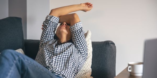 Frau am Sofa ist nach der Arbeit zu müde für alles