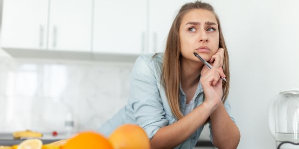 Frau mit Einkaufszettel überlegt: Was ist Histamin und welche Lebensmittel kann ich essen?