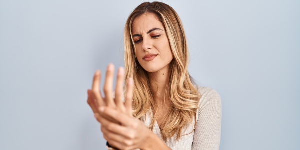 Frau mit rheumatischen Beschwerden in der Hand