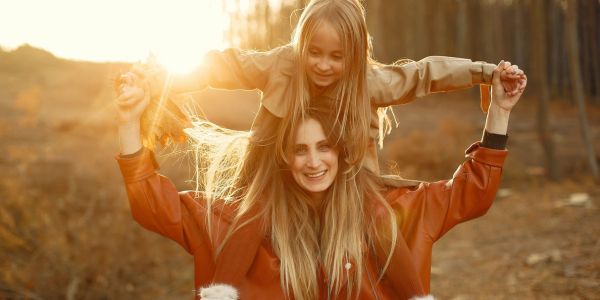 Frau und Kind tanken Vitamin D im Herbst in der Sonne