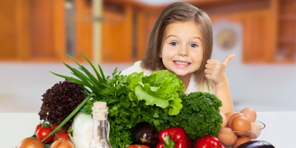 Kind mit einem Berg Gemüse für Vitamine und Nährstoffe