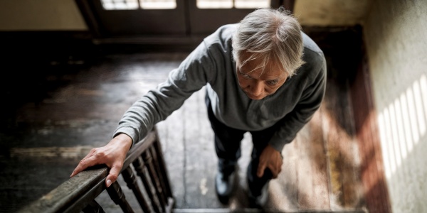 Mensch mit Sarkopenie will die Treppe hochsteigen