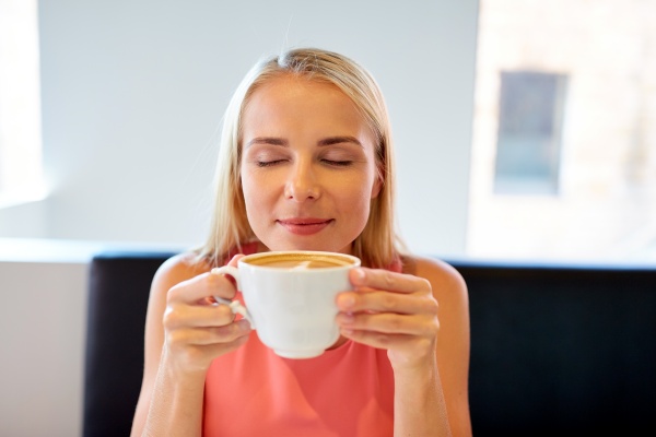 Frau lenkt sich mit Kaffee ab, um leichter mit dem Rauchen aufzuhören