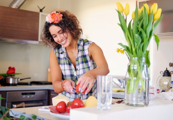 Frau schneidet Tomaten, um Alzheimer vorzubeugen