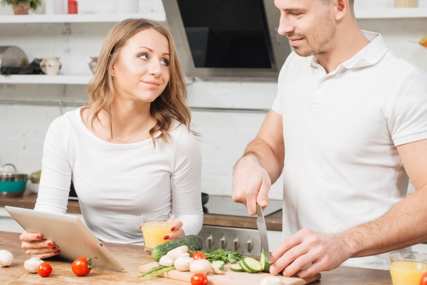 Mann und Frau kochen mit Gemüse