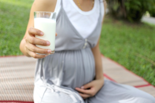 Schwangere Frau hält ein Glas Milch