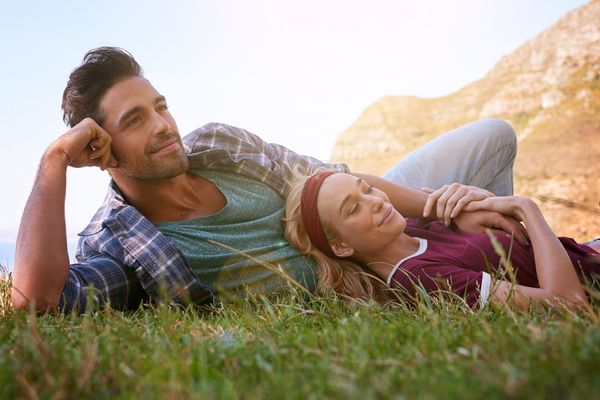 Zufriedener Mann liegt mit Frau im Gras